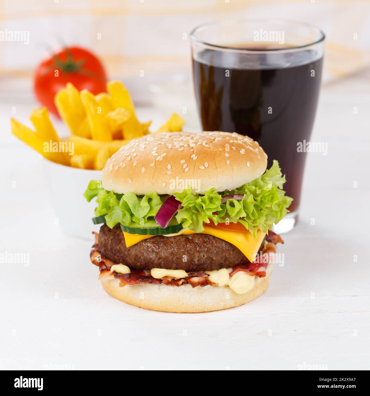 Hamburger Cheeseburger pasto fast food con bevanda di cola e French Fries in una piazza di legno Foto Stock