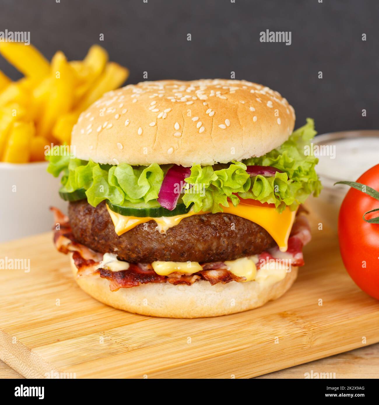 Hamburger Cheeseburger fast food con French Fries su una piazza di legno Foto Stock