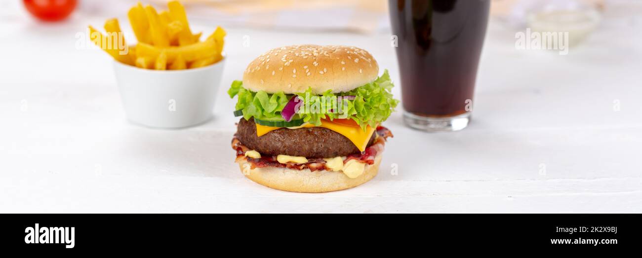 Hamburger Cheeseburger pasto fast food con bevanda di cola e French Fries su una tavola di legno panorama Foto Stock