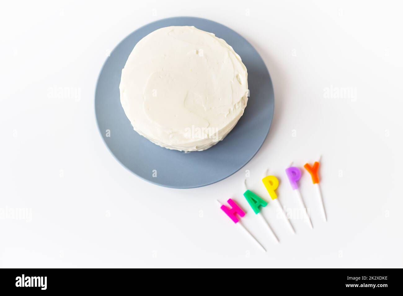 Preparazione per una torta di compleanno, l'iscrizione felicità su un biscotto cremoso. Vacanza a sorpresa e concetto di compleanno. Foto Stock