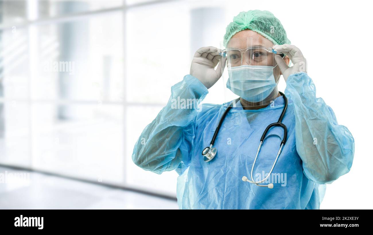 Medico asiatico indossare visiera di protezione e DPI si adatta nuovo normale Per controllare il paziente proteggere l'infezione di sicurezza Covid-19 focolaio di Coronavirus a. allattamento in quarantena Foto Stock