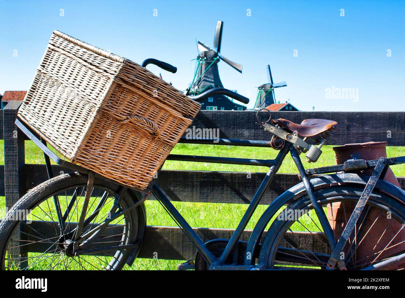 Bicicletta con mulino a vento e sfondo cielo blu. Paesaggio paesaggistico di campagna vicino ad Amsterdam nei Paesi Bassi. Foto Stock