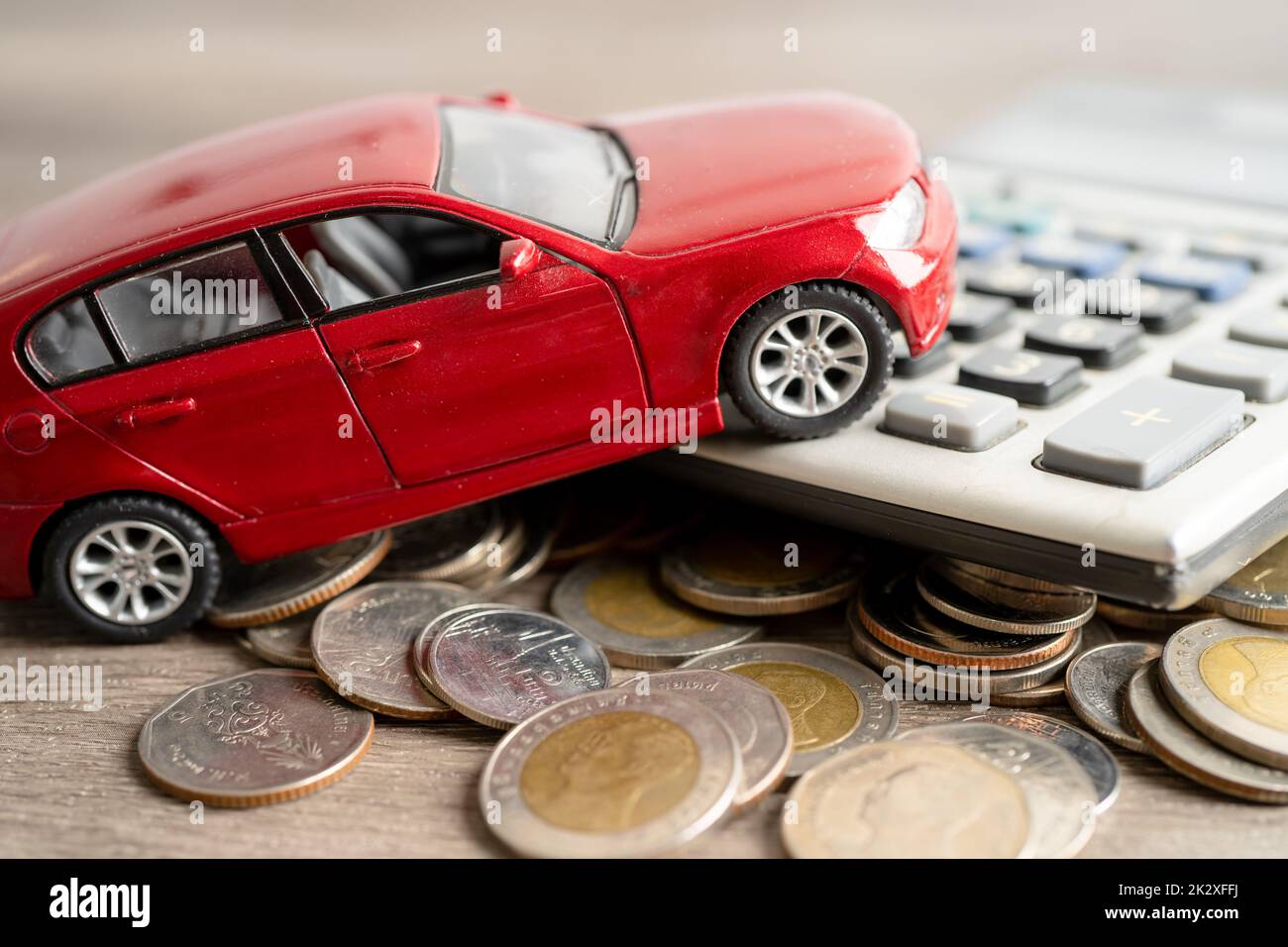Auto su monete e calcolatrice prestito auto, finanza, risparmio di denaro, assicurazione e leasing concetto di tempo. Foto Stock