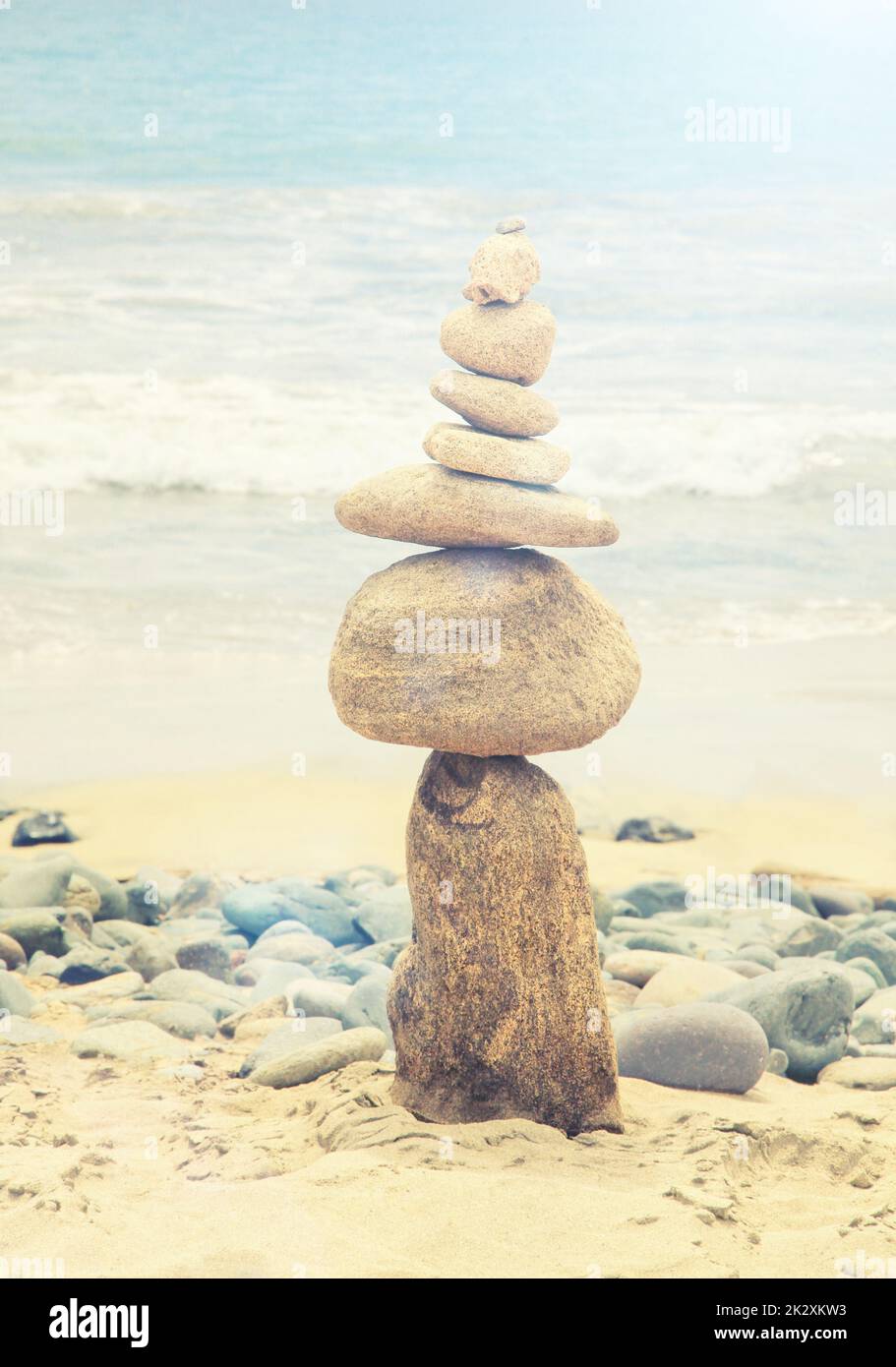 Pietre equilibrato su una spiaggia di ciottoli durante il tramonto. Foto Stock