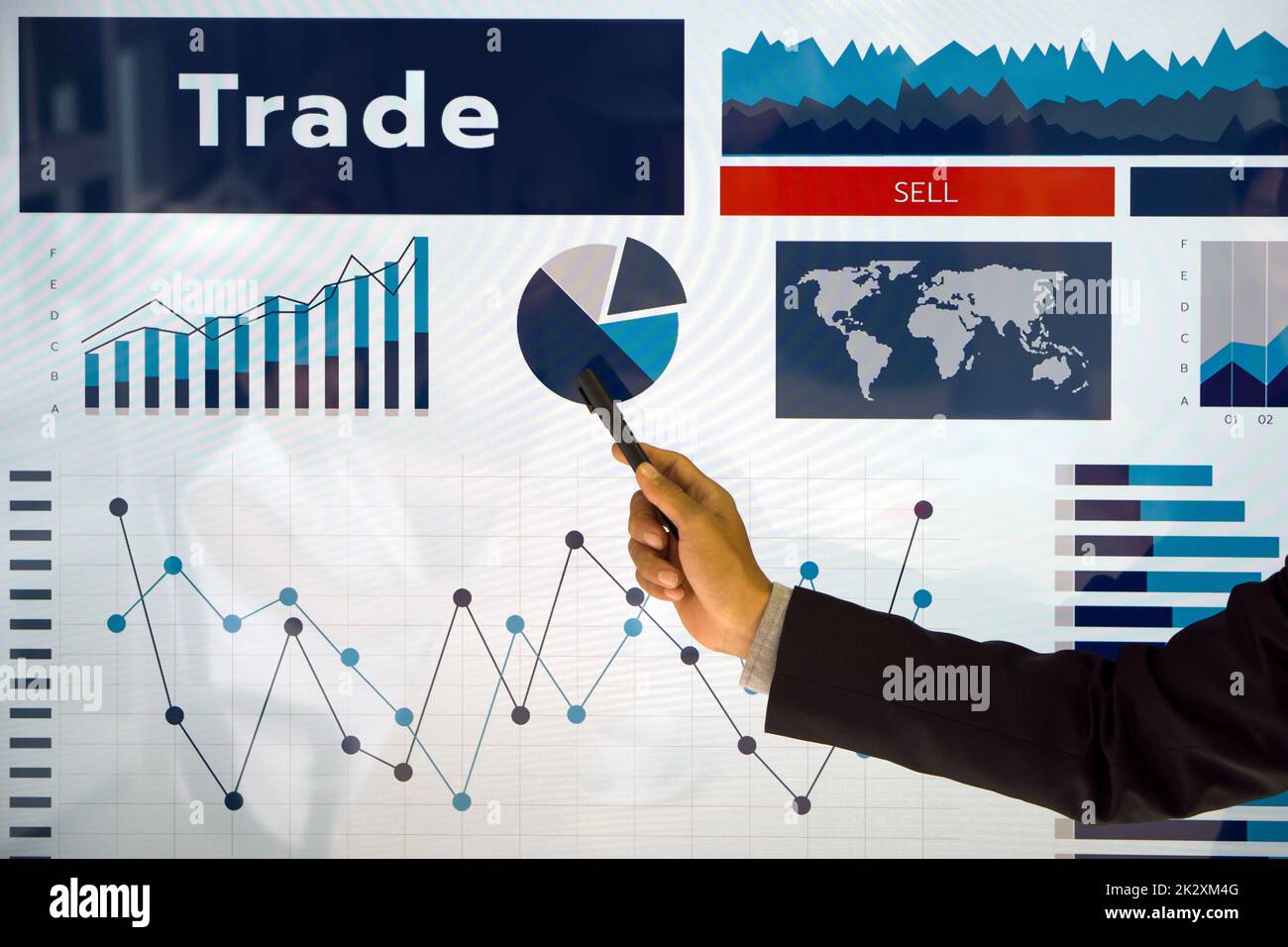 Closeup uomo d'affari in abito nero con penna che punta al grafico a torta sul monitor di presentazione. Foto Stock