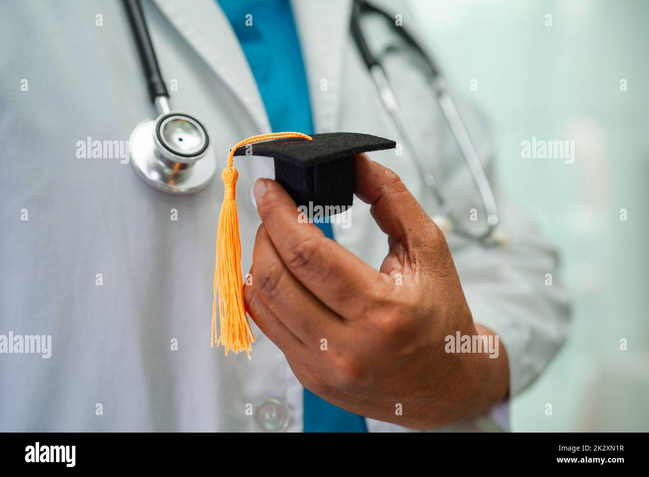 Donna asiatica medico in possesso di cappello di laurea in ospedale, concetto di educazione medica. Foto Stock