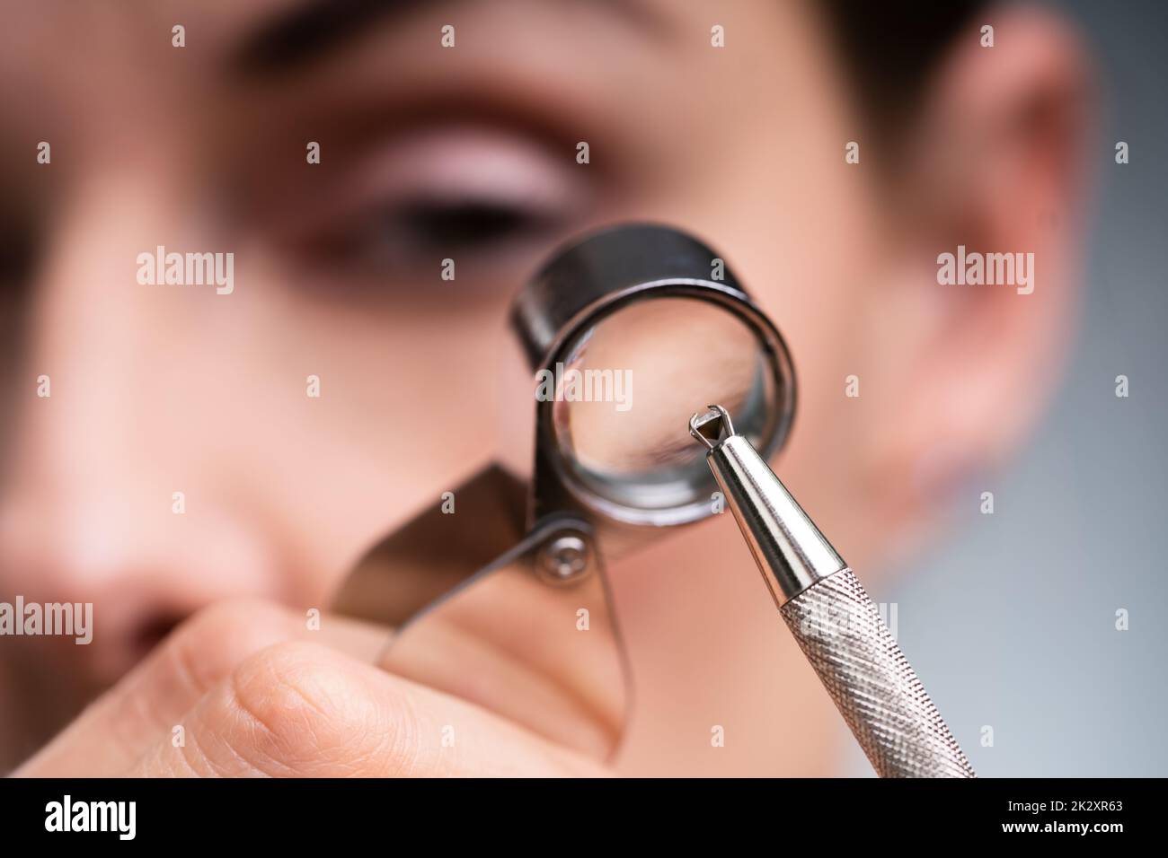 Gioielliere che guarda il diamante attraverso la lente d'ingrandimento Foto Stock
