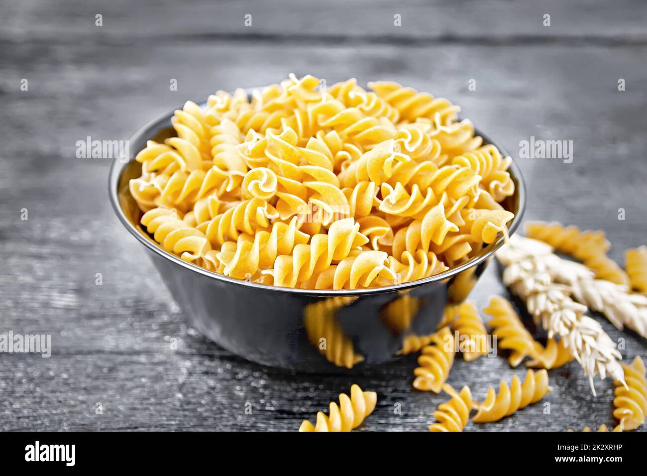 Fusilli grano intero in ciotola a bordo Foto Stock