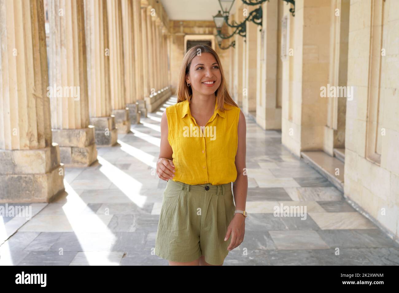 Giovane studentessa sorridente che fa turismo culturale in Europa Foto Stock