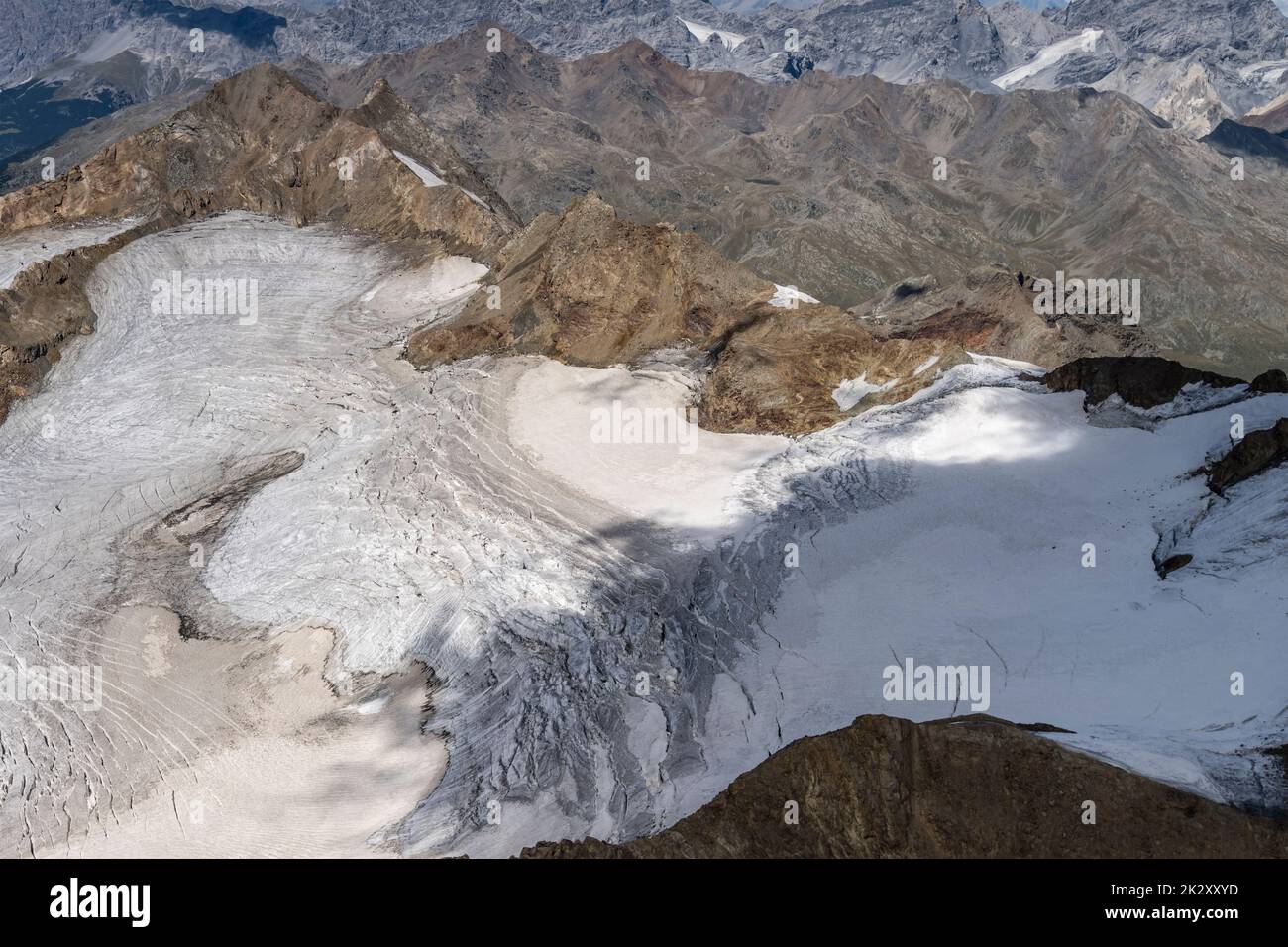 Ripresa aerea, da un aliante, di copertura di ghiaccio ridotta al ghiacciaio di Dosegu dal riscaldamento globale , ripresa dal sud-ovest nella luminosa luce estiva, Alpi, Italia Foto Stock