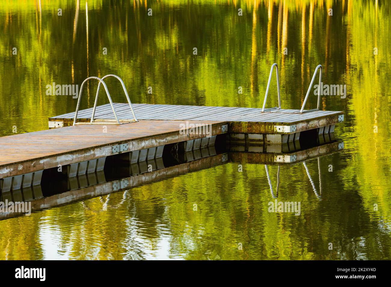 Molo di legno vuoto su un lago tranquillo la mattina d'estate Foto Stock