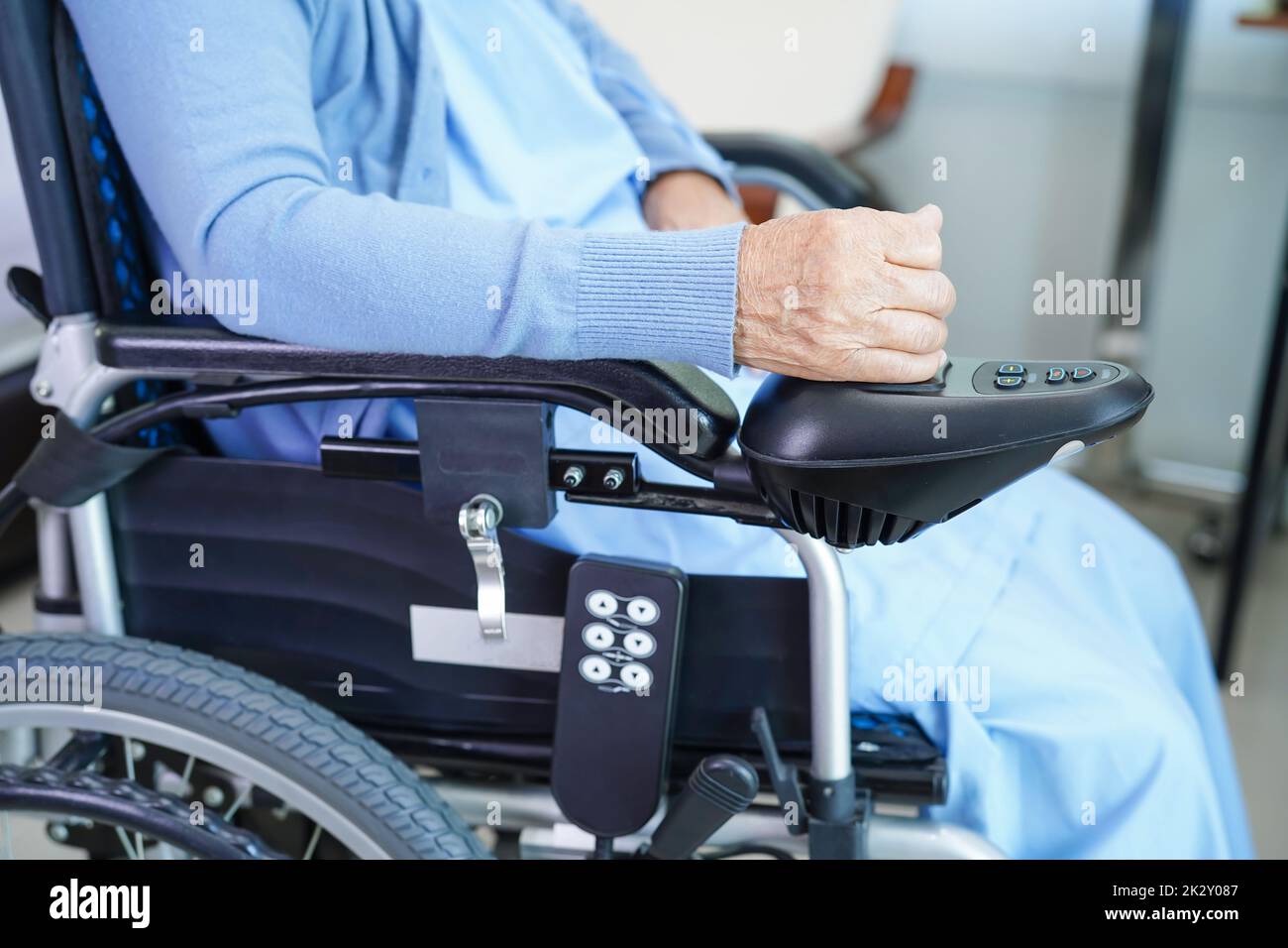 Paziente asiatico anziano invalidità donna seduta su sedia a rotelle elettrica nel parco, concetto medico. Foto Stock