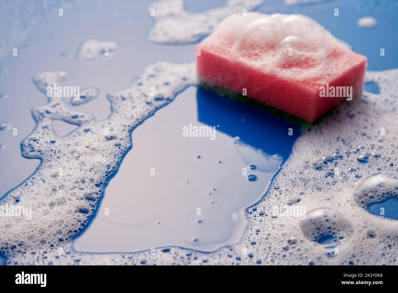 Spugna su superfici bagnate e saponate Foto Stock