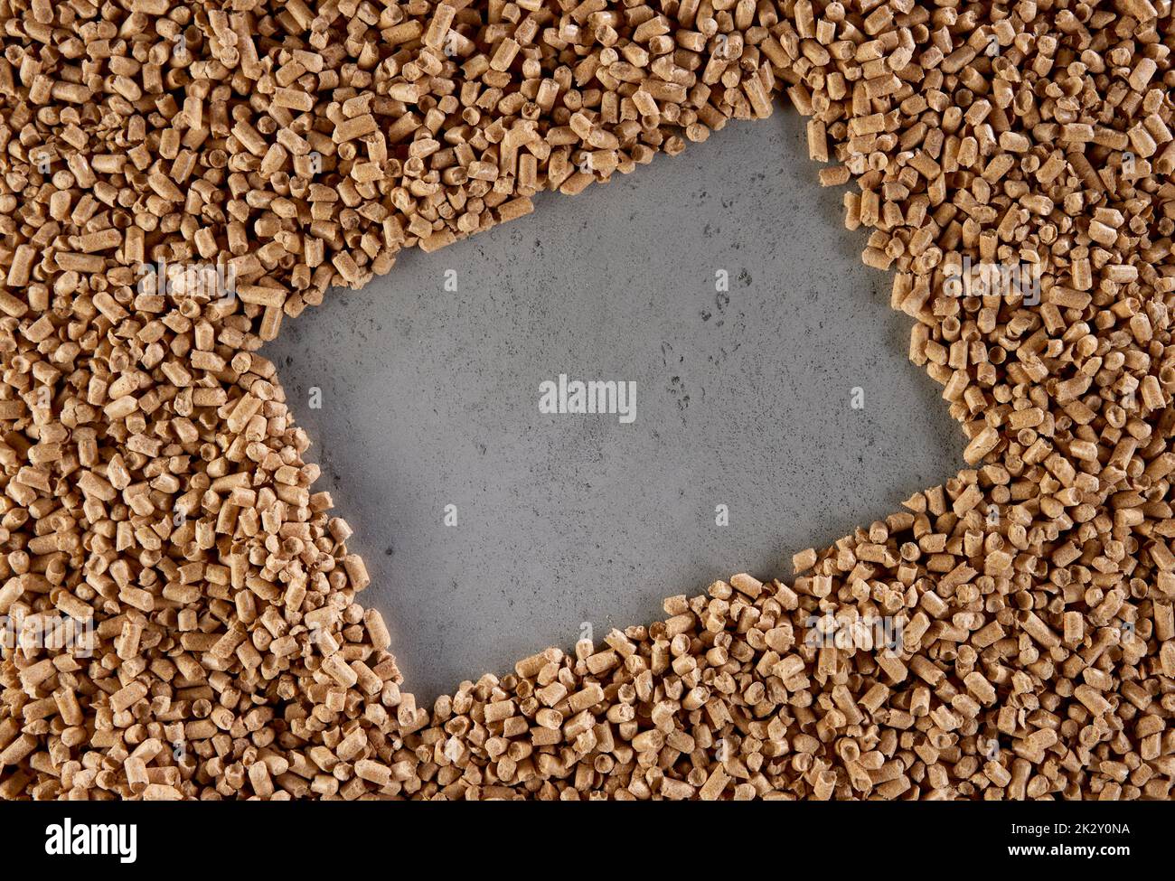 Pellets sparsi su tavola di calcestruzzo in forma di cornice rettangolare Foto Stock