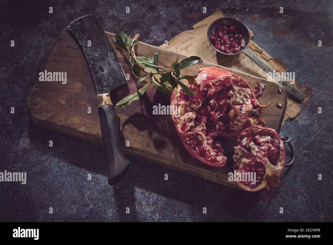 Deliziosa melograna con coltello sul tagliere Foto Stock
