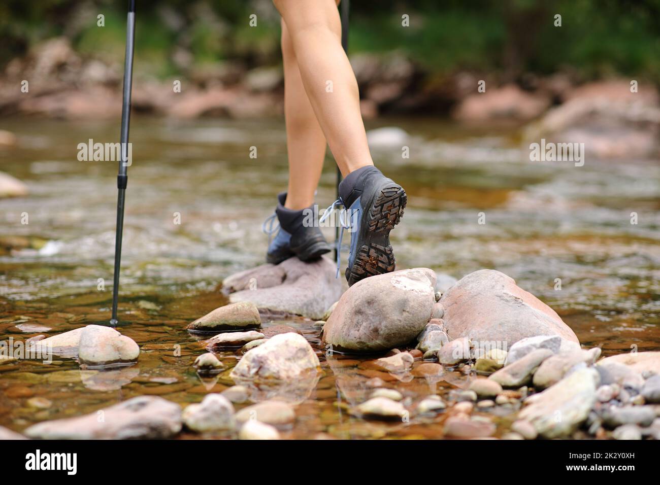 Trekker gambe a piedi attraversando il fiume Foto Stock