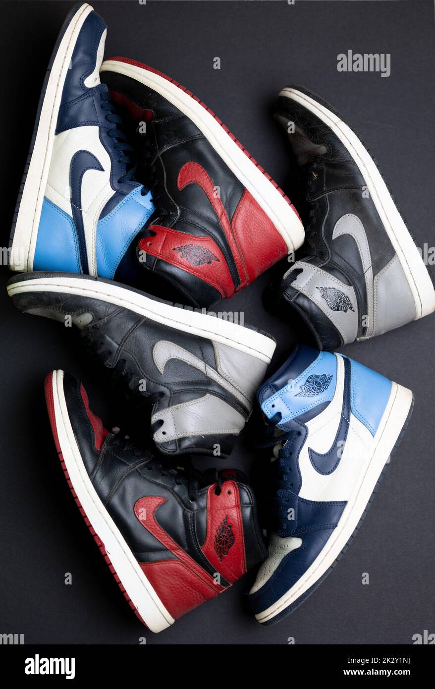 La vista verticale dall'alto delle coppie rossa, grigia e blu di Nike  Banned Air Jordan 1 sulla superficie nera Foto stock - Alamy