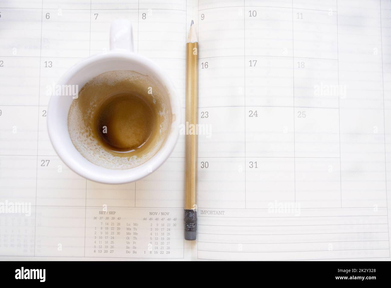 svuotare la tazza di caffè su un diario di lavoro Foto Stock