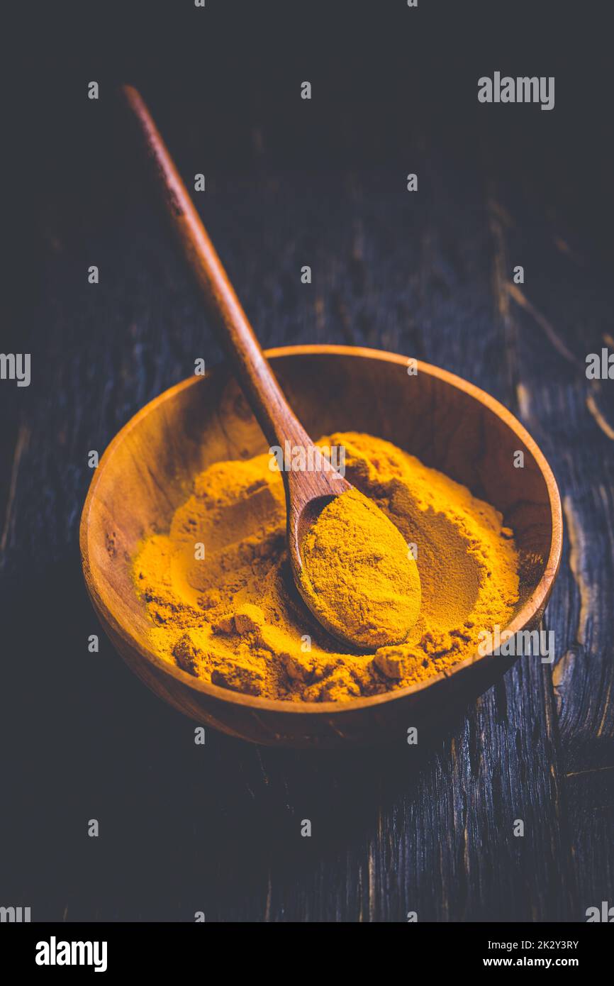 Curcuma in polvere indiana, curcuma spezia in un piccolo recipiente con cucchiaio, Haldi polvere Foto Stock