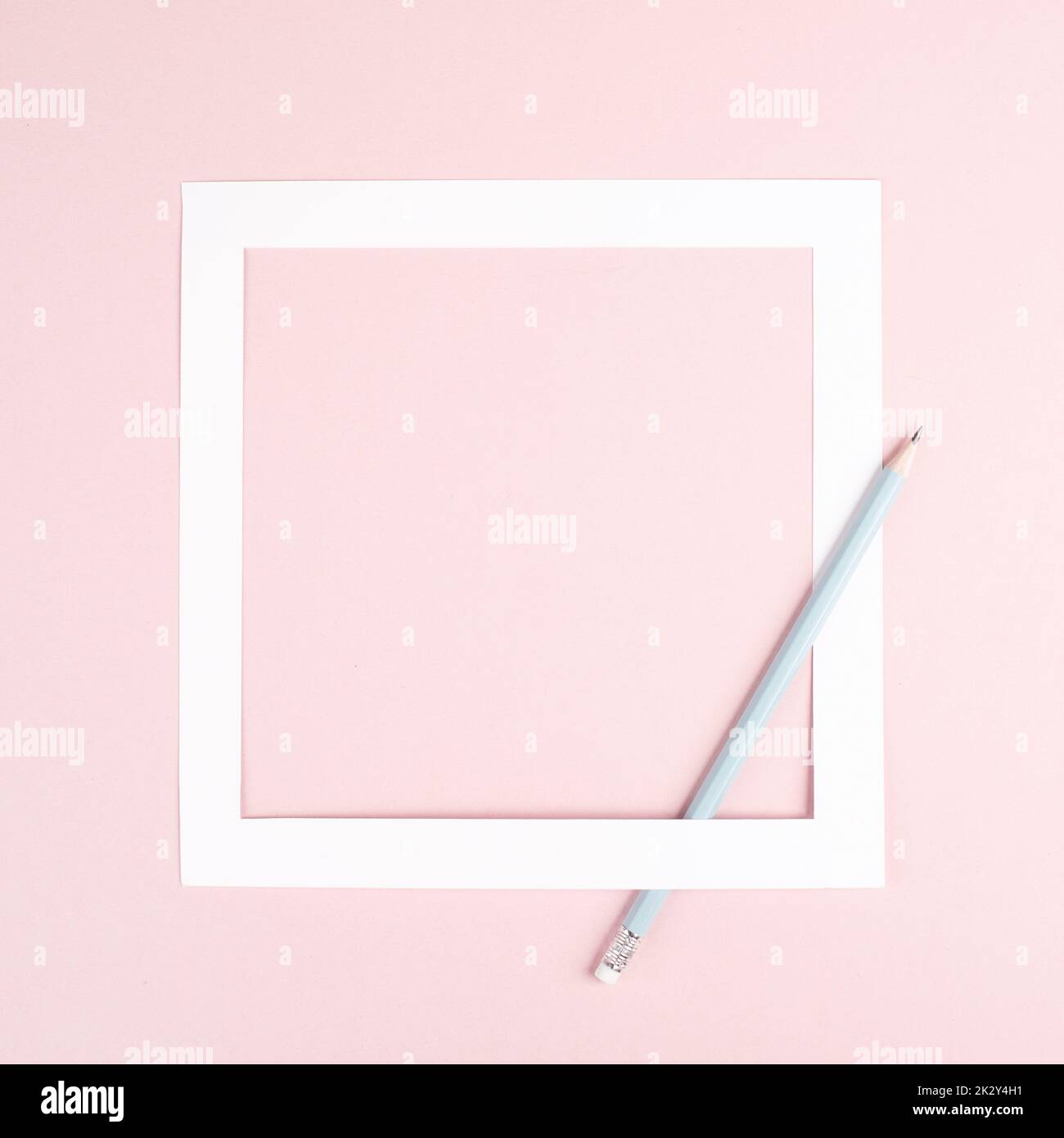 Matita su sfondo di carta rosa, cornice bianca con spazio di copia per testo, minimalismo, concetto creativo e aziendale, colore pastello Foto Stock