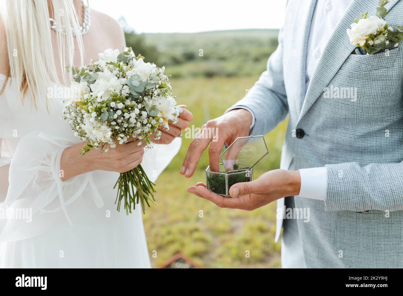 Primo piano della sposa che dà la mano allo sposo per mettere sul suo anello durante la cerimonia nuziale. Vita sposata e felice concetto di famiglia. Foto Stock