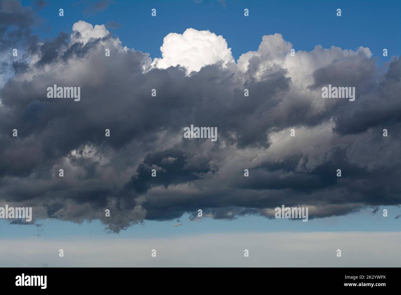nuvole grigie scure su cielo blu Foto Stock