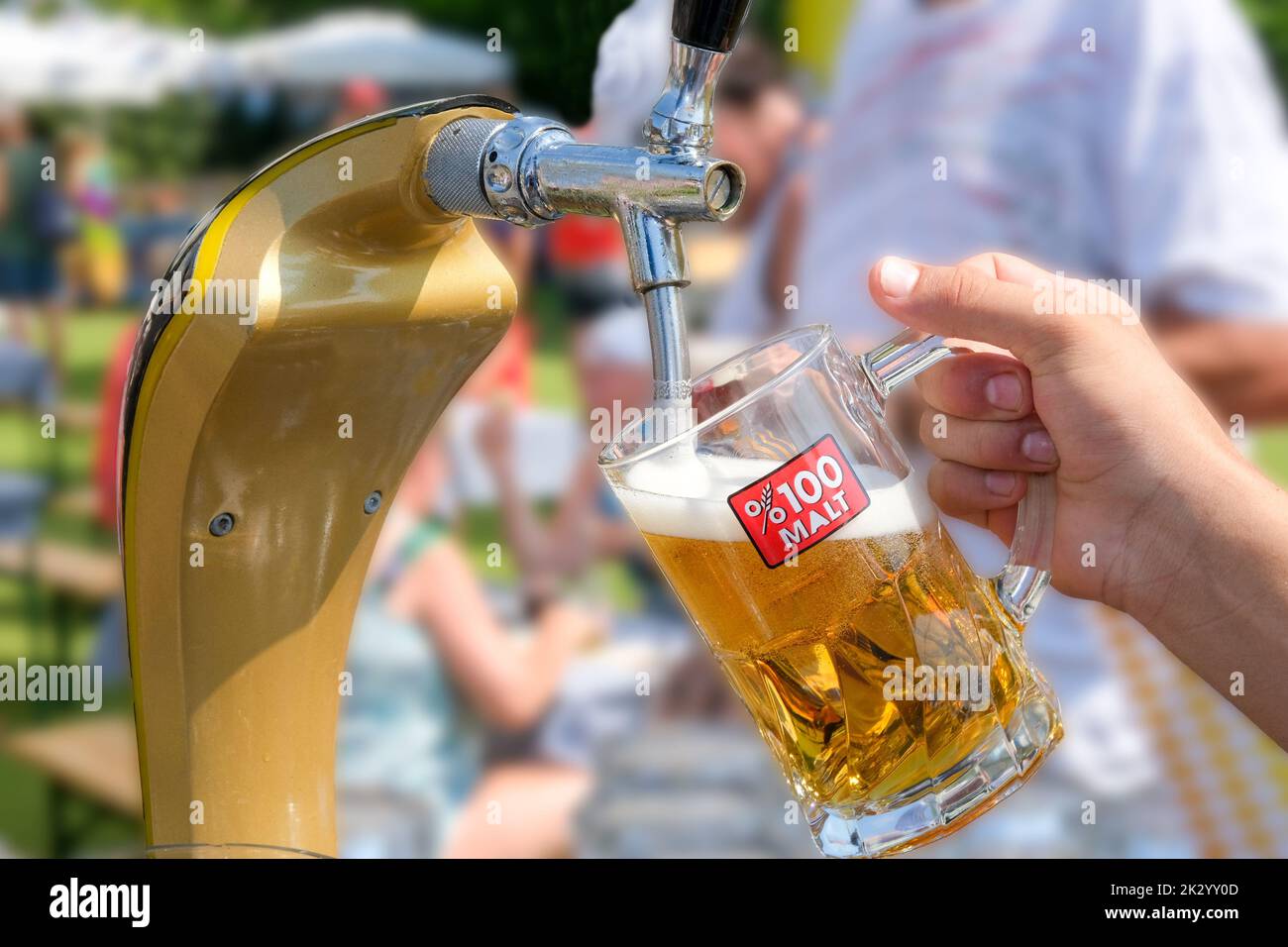 Birra che si riversa in un bicchiere in un bar, oktoberfest il giorno di sole, spazio copia. Foto Stock