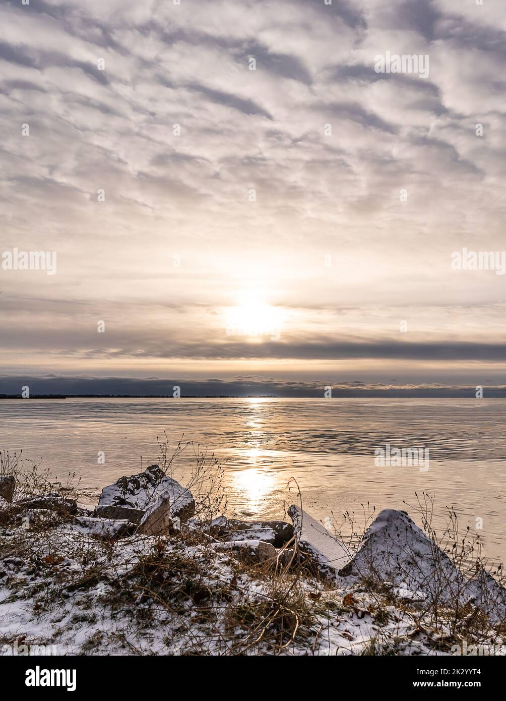 Una costa rocciosa innevata che si affaccia durante il tramonto a Tawas Bay, Michigan, USA Foto Stock