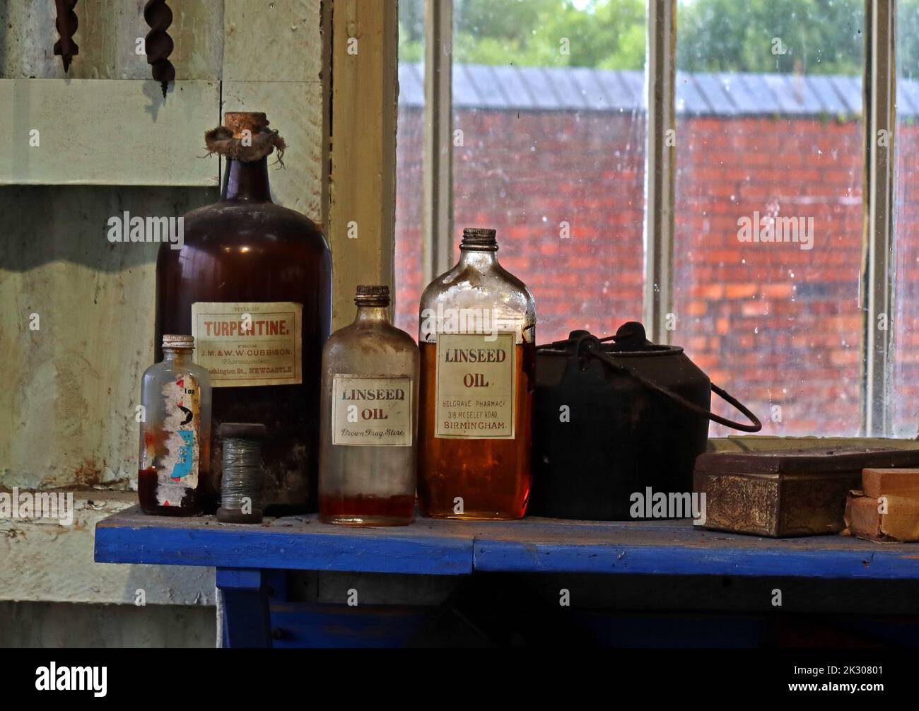 Bottiglie di olio di capannone per utensili, semi di lino, torpentina su un ripiano Foto Stock