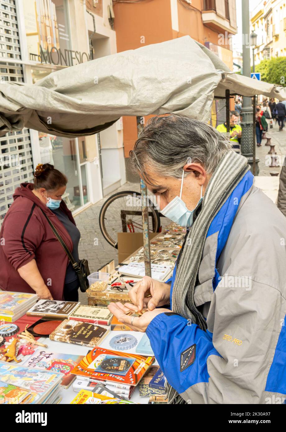 Stile di vita di Siviglia. Il vecchio compratore di monete si stalla a Mercadillo Histórico 'El jueves', Siviglia, Spagna Foto Stock