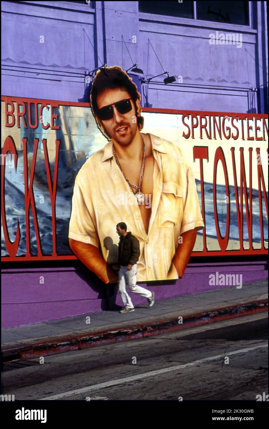 Un giovane uomo passa davanti a un cartellone Bruce Springsteen per Lucky Town sul lato del Whisky A Go sulla Sunset Strip di Los Angeles, CA, 1992 Foto Stock