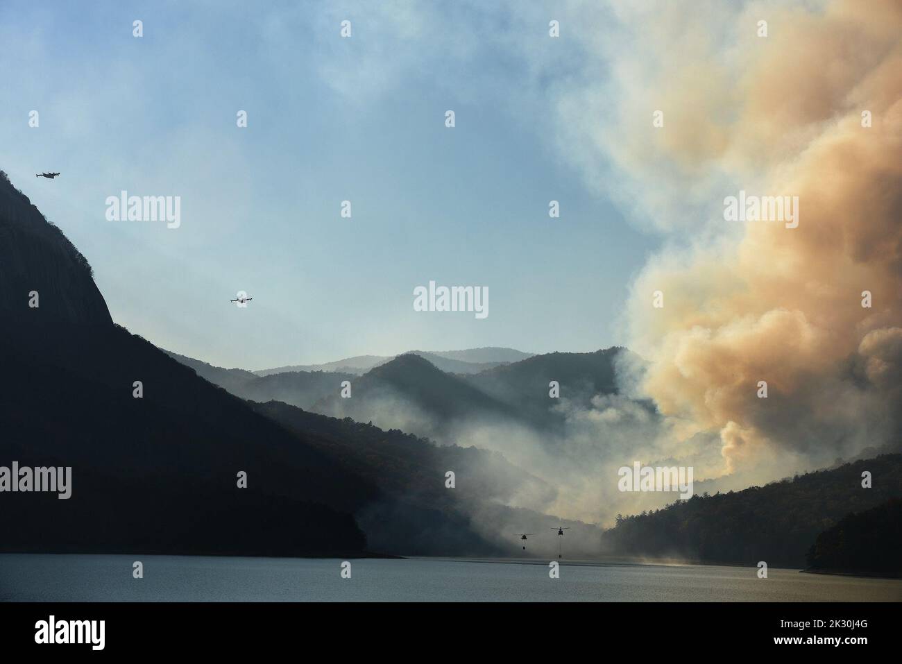 La Carolina del Sud esercito nazionale Guard CH-47 Chinook pesanti carichi di sollevamento per elicotteri e un UH-60L Falco nero medio sollevamento elicottero utility da 59th aviazione il comando delle truppe e gli equipaggi supportano la Carolina del Sud commissione forestale per contenere un incendio remota nei pressi di Table Rock, Pickens County, South Carolina, nov. 20, 2016. (U.S. Esercito nazionale Guard photo by Staff Sgt. Roberto Di Giovine) Foto Stock