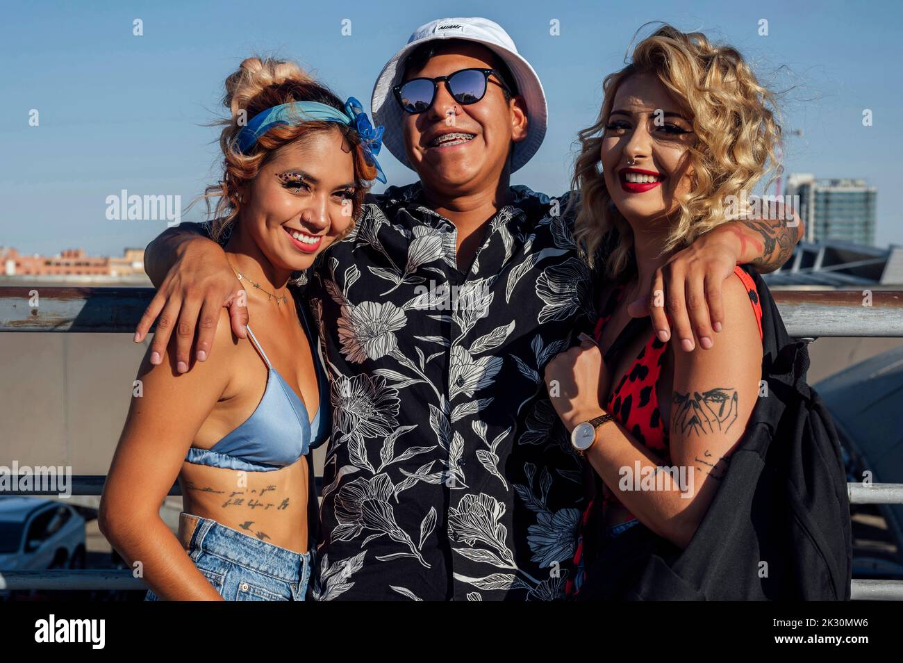 Amici felici in piedi con le braccia intorno nella giornata di sole Foto Stock