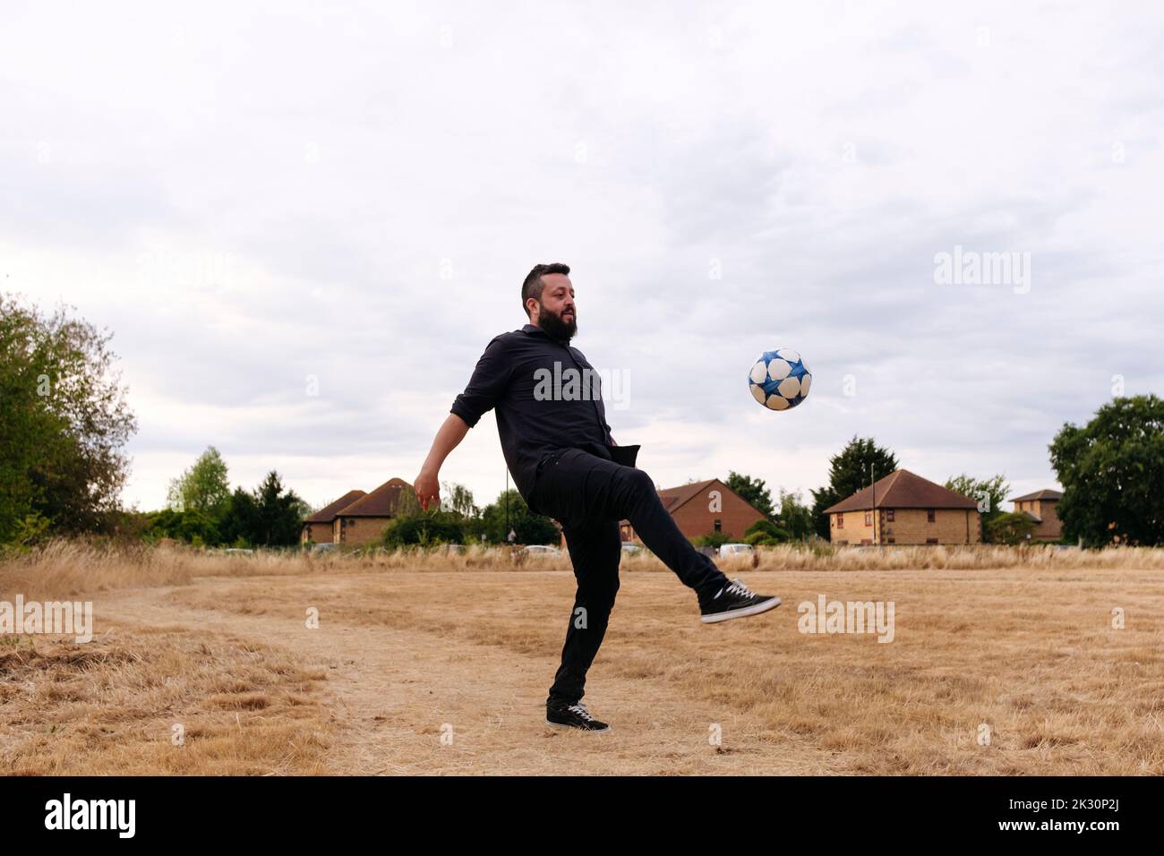 Uomo maturo che gioca con la palla di calcio in campo Foto Stock
