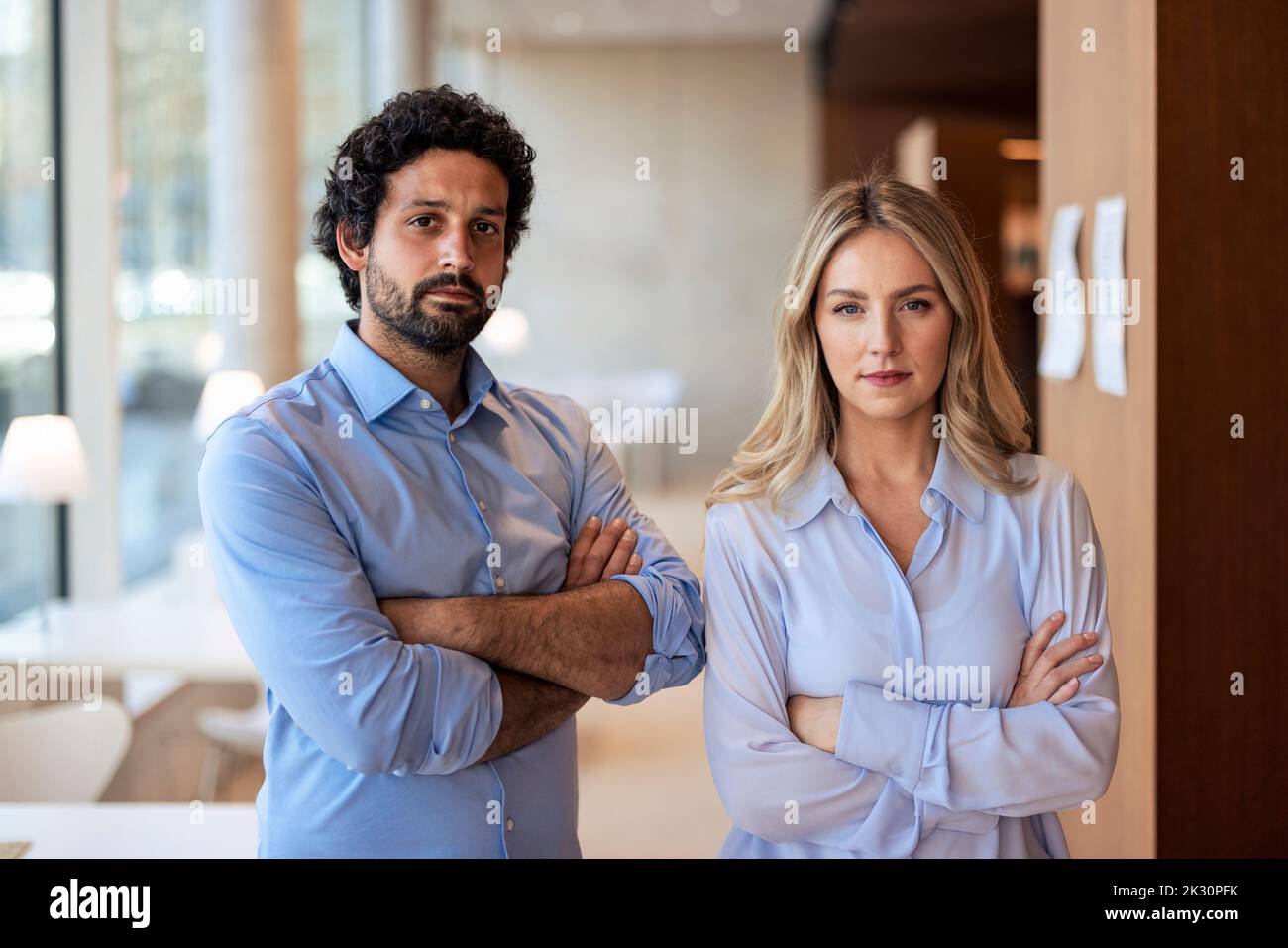 Professori fiduciosi con armi incrociate all'università Foto Stock