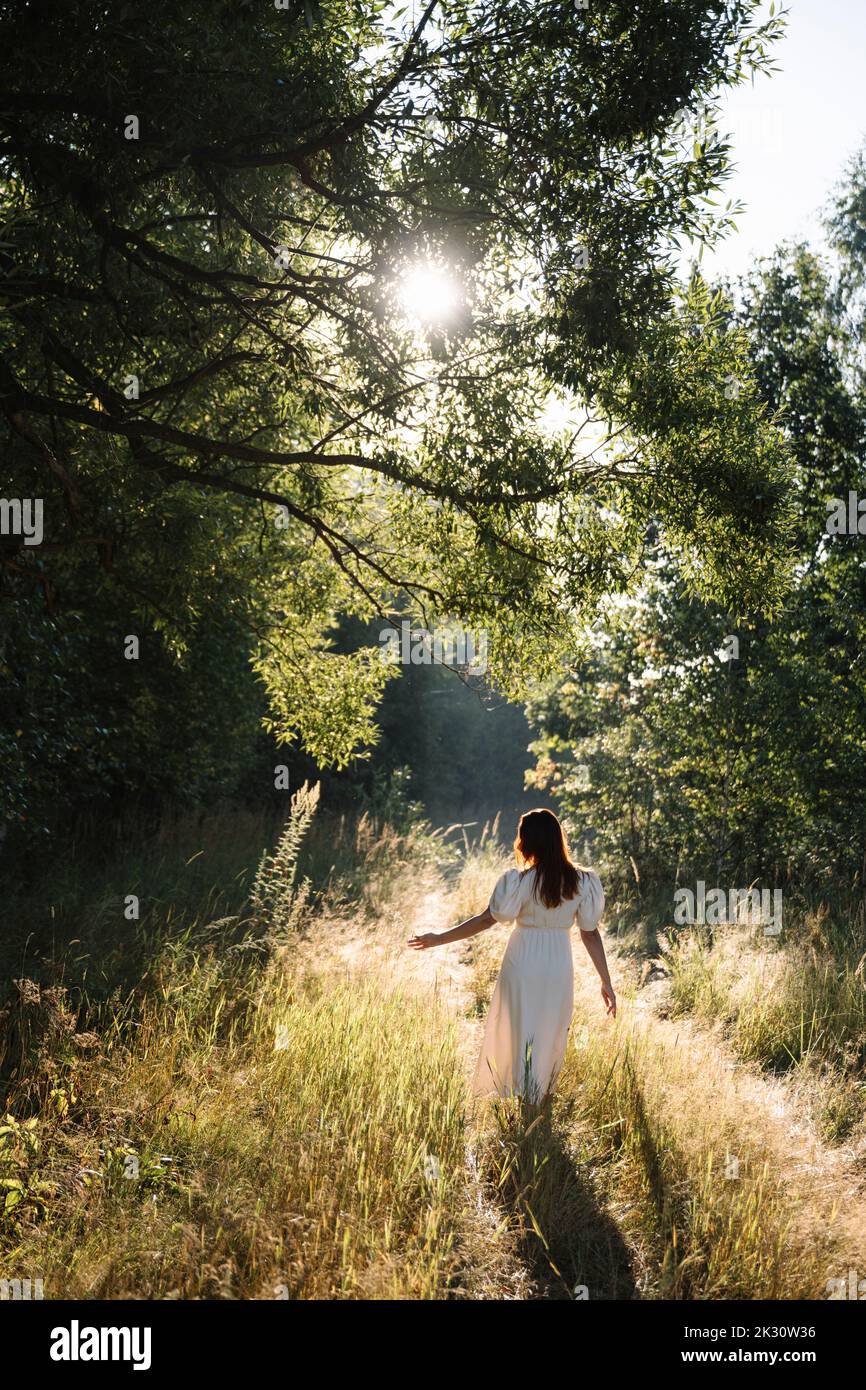 Donna che passa da sola a piedi nella foresta Foto Stock