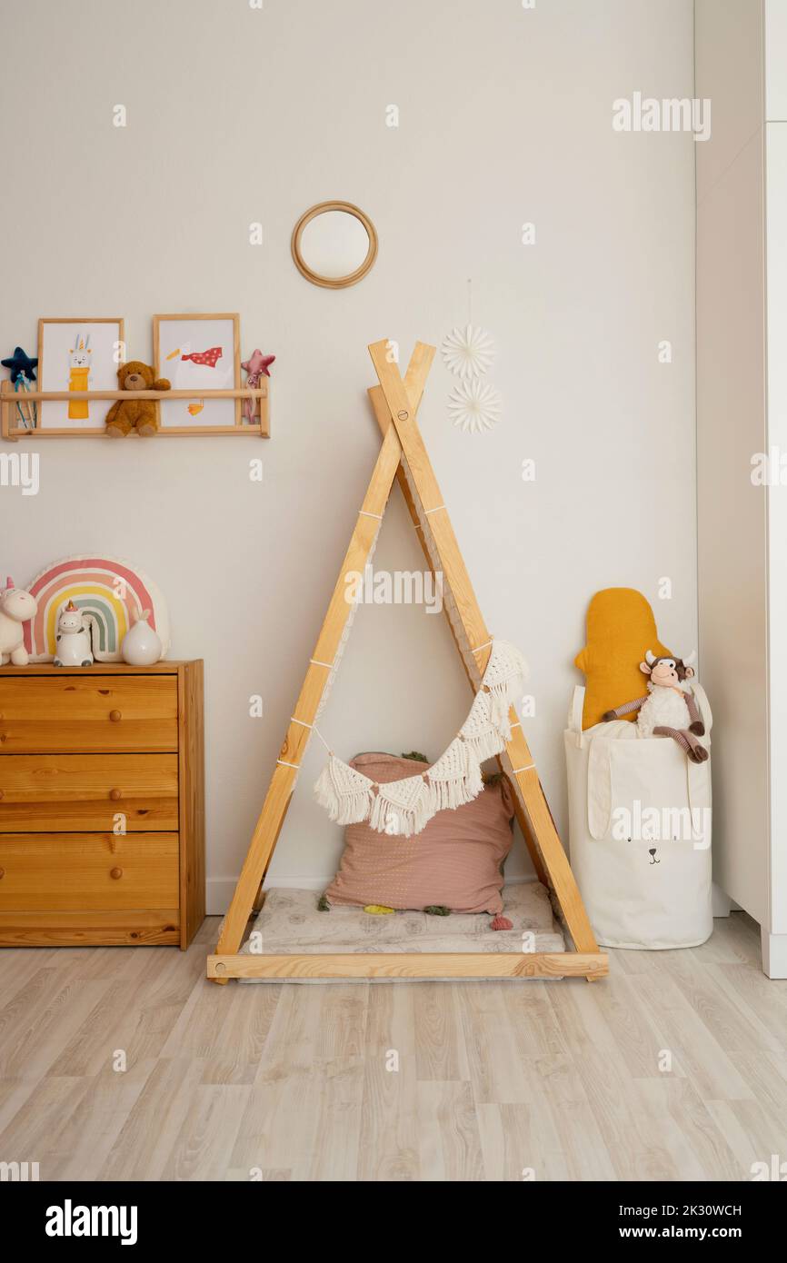 Tenda a forma di triangolo in legno sul pavimento a casa Foto Stock