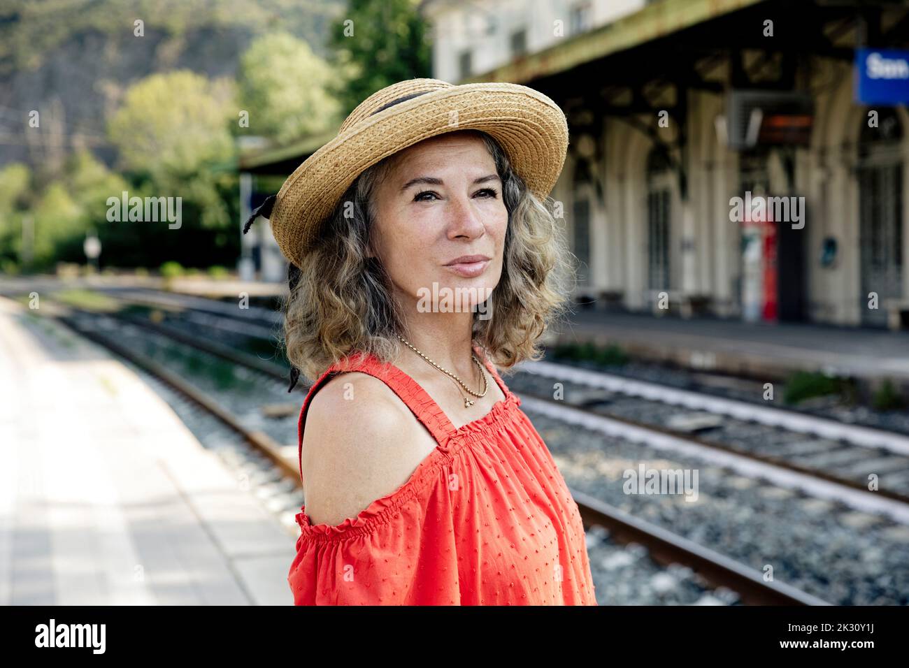 Donna che indossa un cappello in attesa del treno alla stazione ferroviaria  Foto stock - Alamy