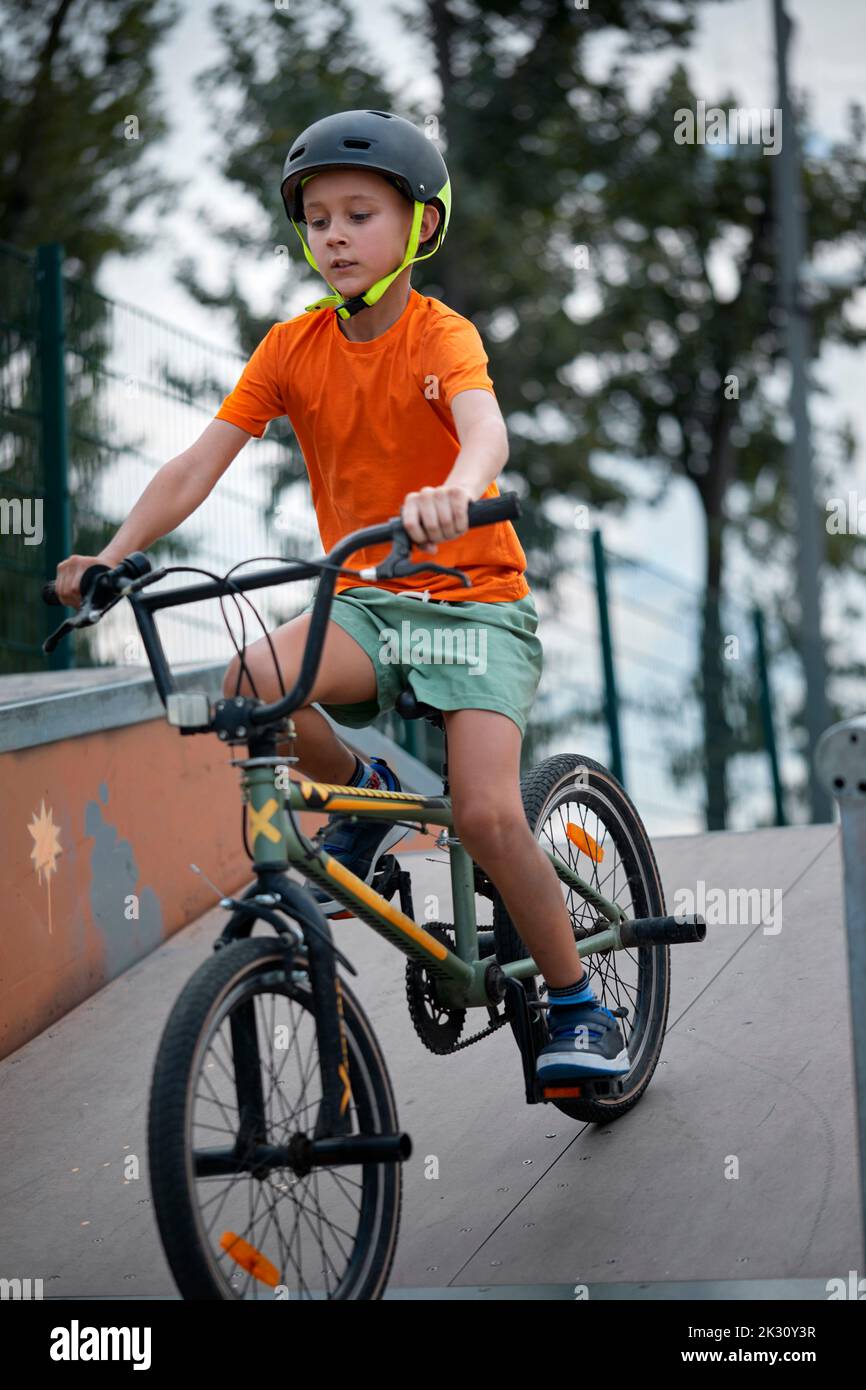 Ragazzo in bicicletta BMX sulla rampa sportiva Foto Stock