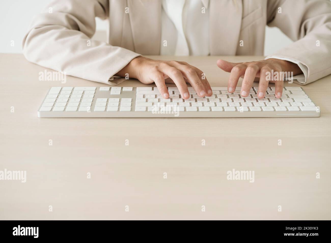 Primo piano di una donna d'affari che digita sulla tastiera alla scrivania Foto Stock