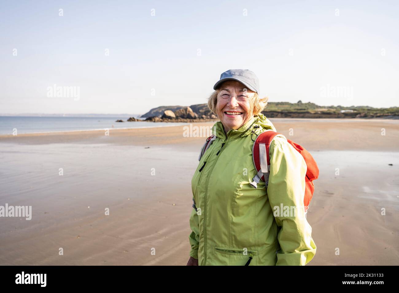 Donna anziana felice in vacanza in spiaggia Foto Stock