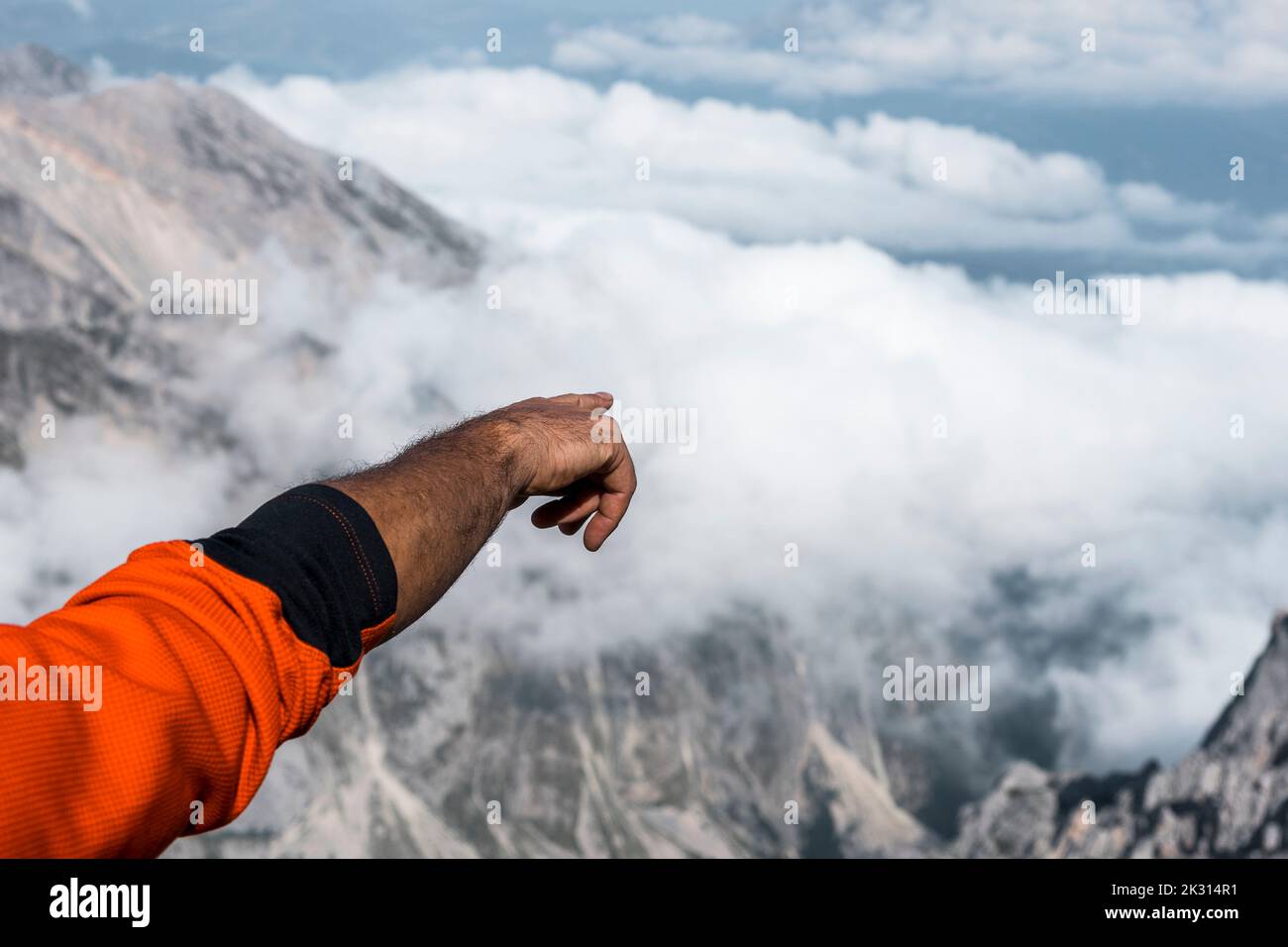 Mano di alpinista gestante dalla cima della montagna Foto Stock