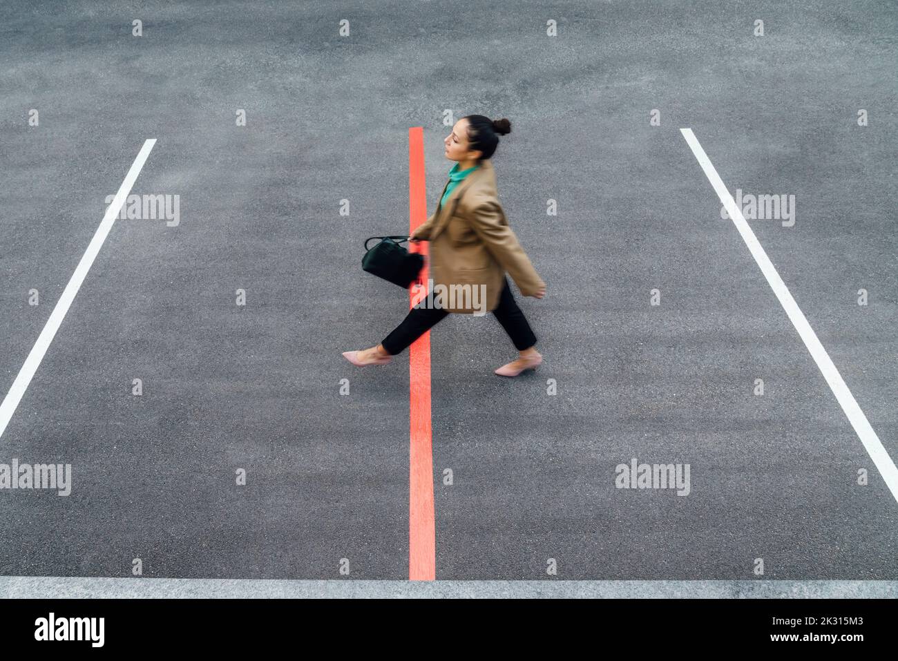 Donna d'affari che cammina sulla linea rossa nel parcheggio Foto Stock