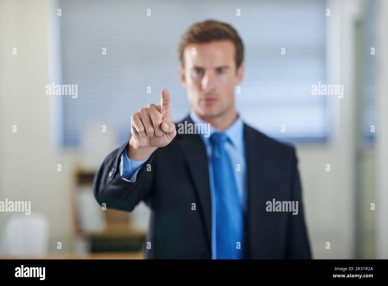 Pianificazione e strategizzazione semplificate con l'interfacciamento moderno. Un bel giovane uomo d'affari che usa un'interfaccia digitale. Foto Stock