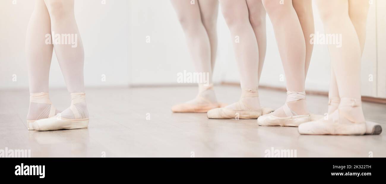 Balletto, piedi di gruppo leader e ballerino in studio di danza in Accademia di artisti con parete bianca e pavimento. Donne squadra, classe o studenti che ballano Foto Stock