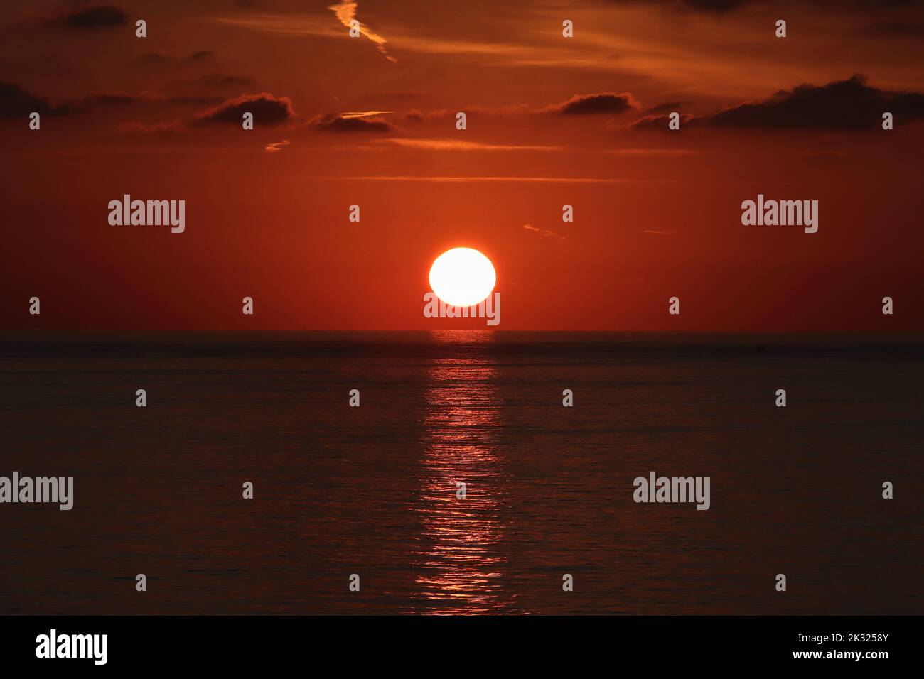 foto del sole che sorge sul mare di prima mattina Foto Stock