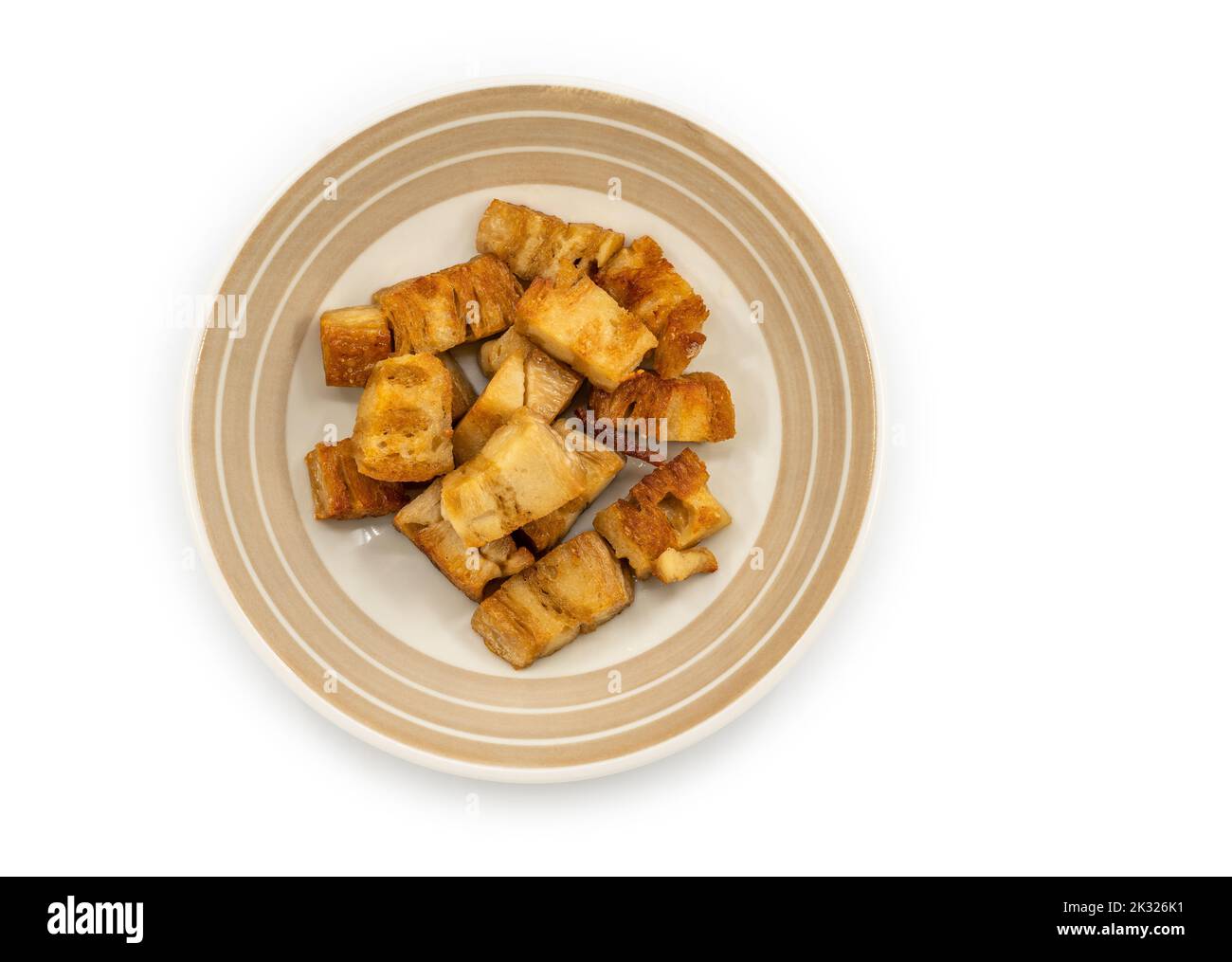 Maiale croccante isolato di pianta di base in piatto bello su sfondo bianco, carne zero cibo, vista dall'alto immagine pianta di base marrone croccante maiale. Foto Stock
