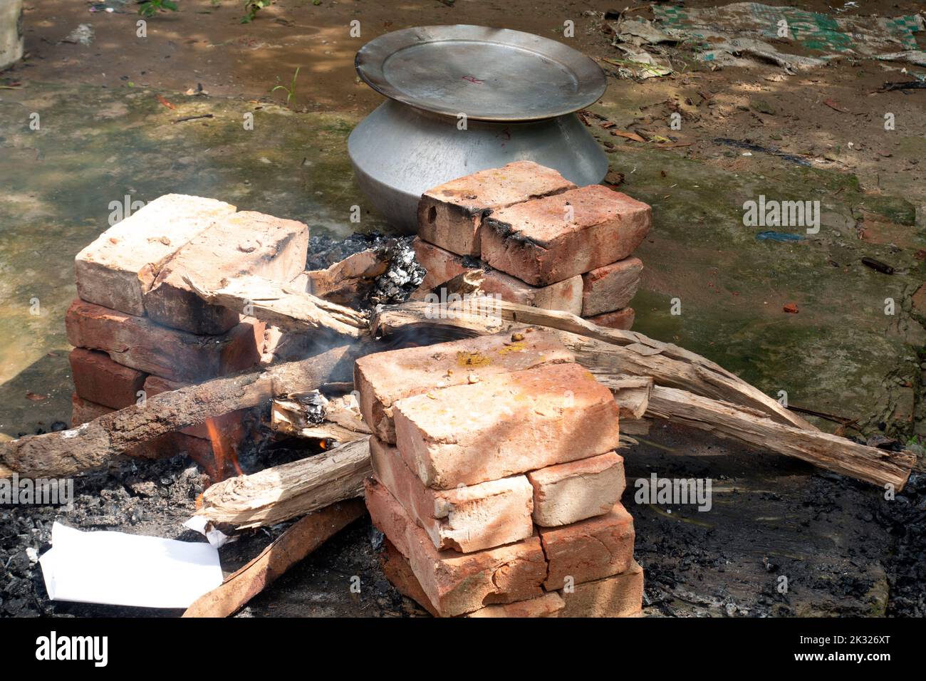 Biryani cucina in un villaggio festa su un forno temporaneo in mattoni. Cucina all'aperto per un sacco di persone in grande padella di alluminio in fuoco di legno. Foto Stock