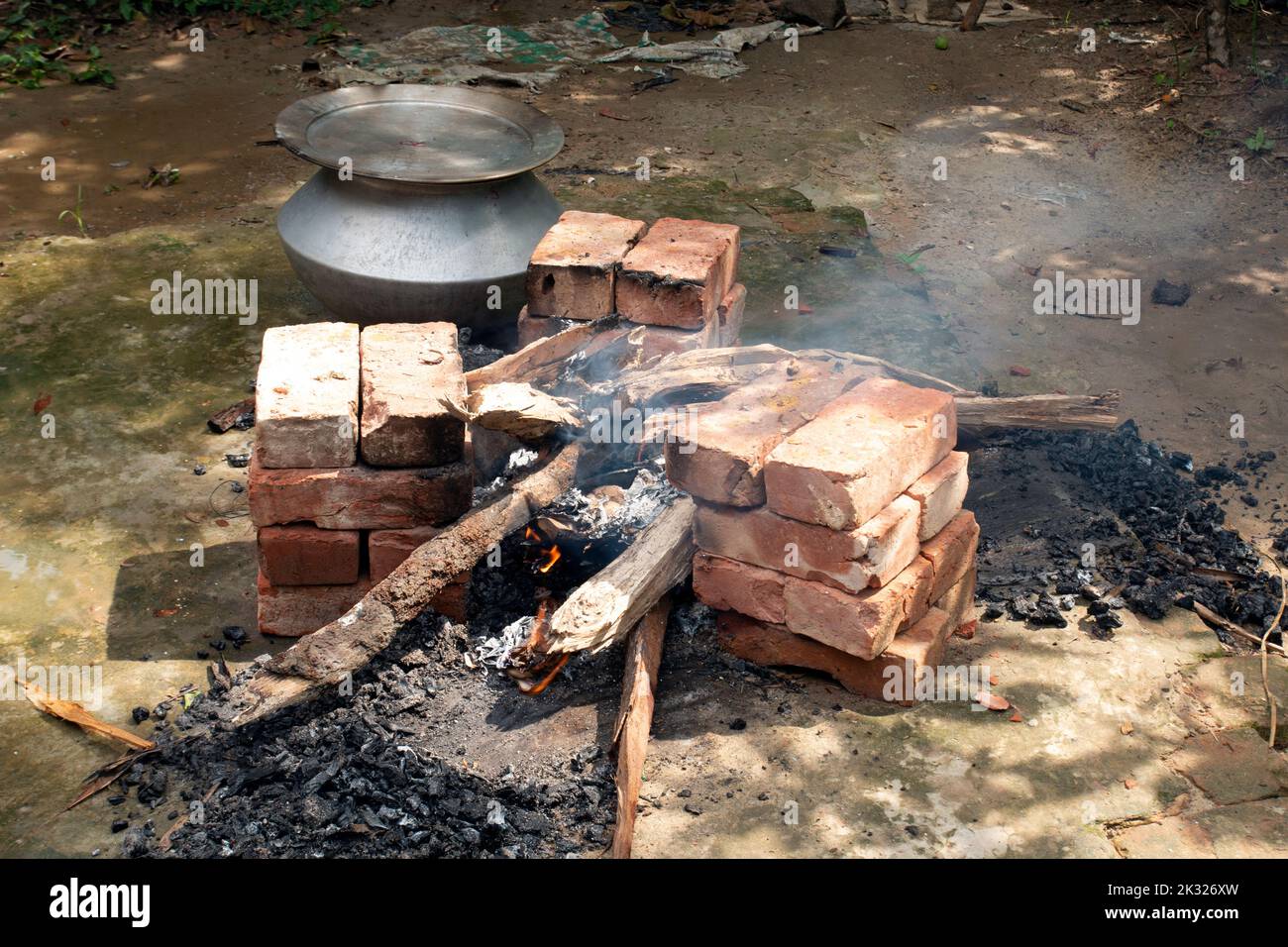 Biryani cucina in un villaggio festa su un forno temporaneo in mattoni. Cucina all'aperto per un sacco di persone in grande padella di alluminio in fuoco di legno. Foto Stock