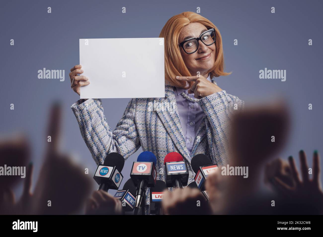 Divertente uomo politico femminile sorridente che mostra un segno bianco alla conferenza stampa Foto Stock